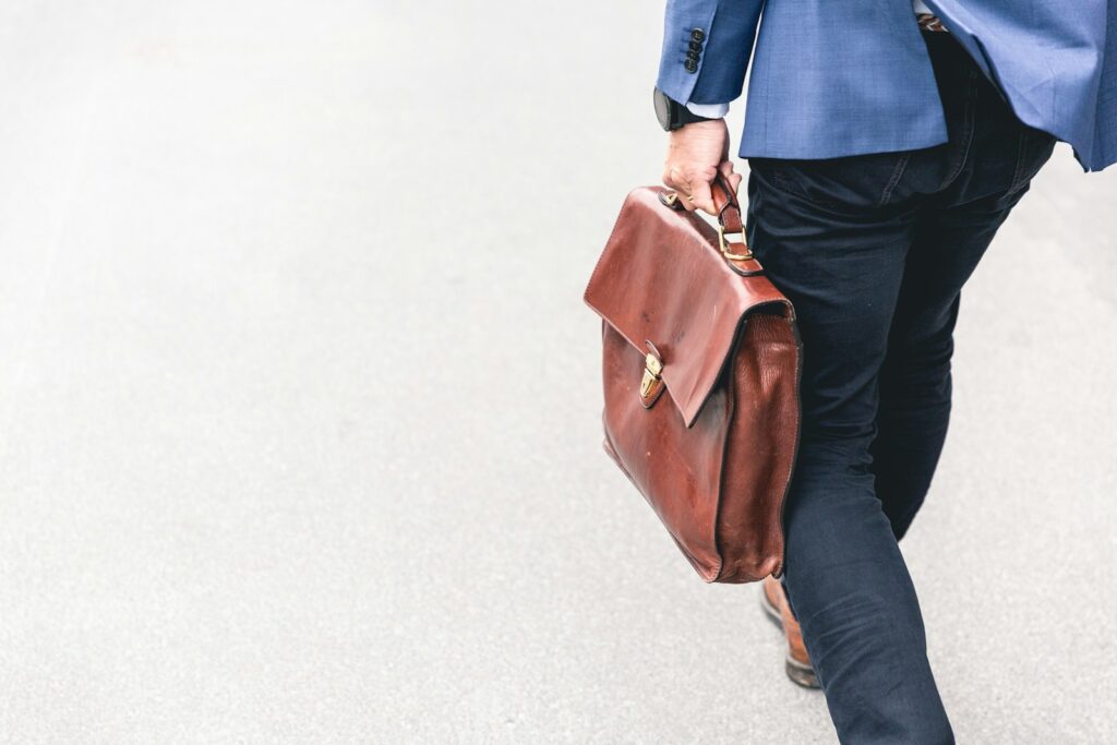 Photo by Marten Bjork person walking holding brown leather bag